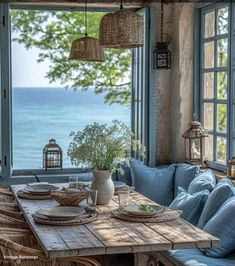 a wooden table sitting in front of a window next to a blue couch and chair