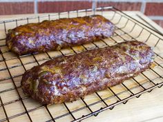 two sausages sitting on top of a metal rack