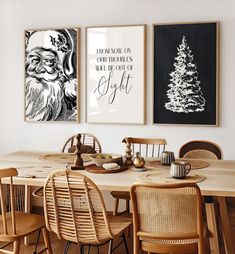 a dining room table with chairs and pictures on the wall above it, along with two christmas trees