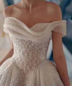 a woman in a white wedding dress is standing with her hands on her hips and looking off to the side