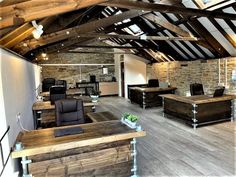 an office with wooden floors and exposed ceilings