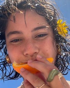 a woman with wet hair eating an orange