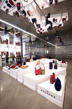 the inside of a shoe store with many purses on display