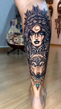 a woman's leg with tattoos on it and two wolfs in the background