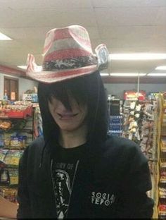 a man wearing a red and white hat standing in front of a grocery store aisle