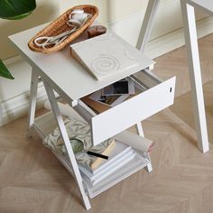 a white table with a basket and some books on it