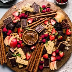 a platter filled with fruit, crackers and chocolate on top of a table