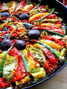 a pan filled with lots of different types of food on top of a wooden table