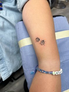 a woman's arm with a small bee tattoo on the left side of her arm