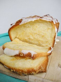 two pieces of bread sitting on top of a cutting board with frosting and icing