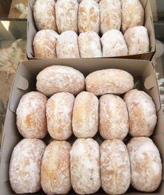 two boxes filled with donuts on top of a table