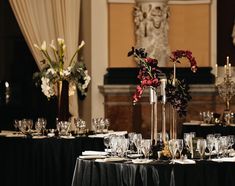 the table is set with wine glasses and flowers