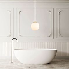 a white bathtub sitting in front of a wall mounted light next to a sink