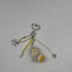 a keychain with a stuffed animal hanging from it's side on a white surface