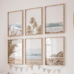 four framed pictures hang on the wall above a bed