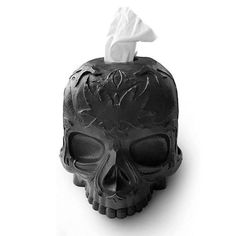 a skull shaped tissue dispenser with a paper towel on it's head