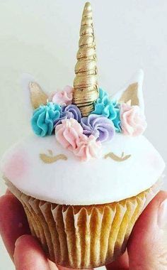 a cupcake decorated with flowers and a unicorn's horn