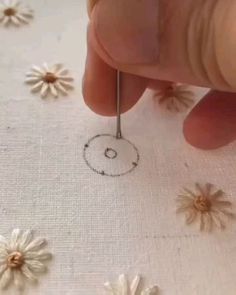 someone is stitching flowers on fabric with needles