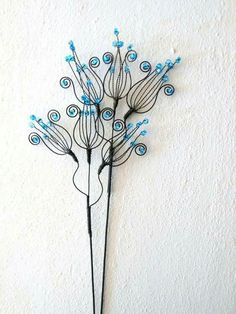 a metal wall hanging with blue flowers on it