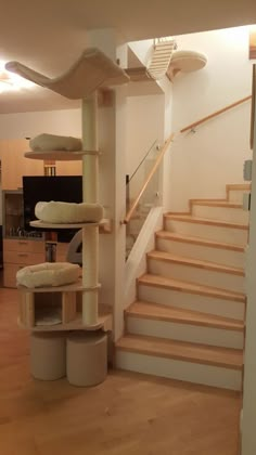 a cat tree in the middle of a living room next to stairs and a couch