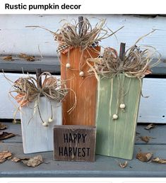 three wooden bags with happy harvest written on them sitting on a bench next to some dry leaves