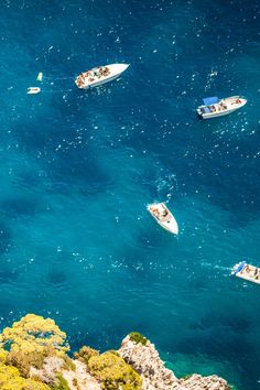 several small boats floating in the blue water