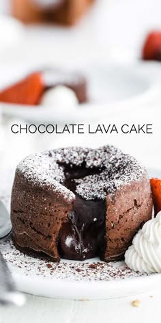 a chocolate lava cake with whipped cream and chocolate sauce on top, sitting on a white plate