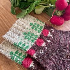 some radishes are laying on the table next to two knitted mitts