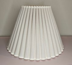 a white lamp shade sitting on top of a table