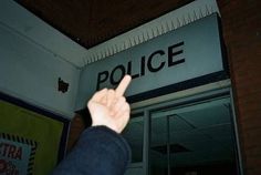 a person points at the police sign on the building