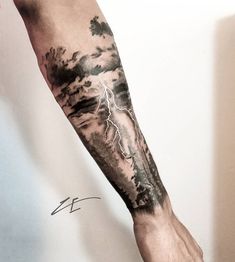 a man's arm with a storm and lightning tattoo on it