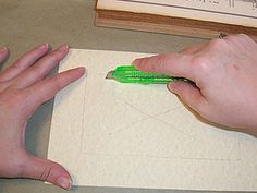 two hands holding a green pen over a piece of paper