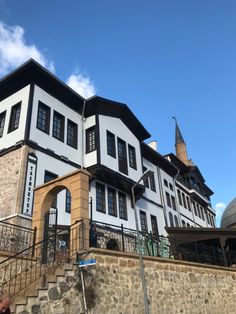 a large white and black building with stairs leading up to it's second story