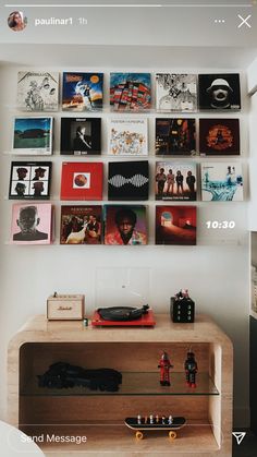 there are many pictures on the wall above this table and below it is a record player