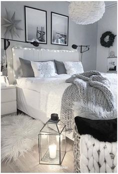 a bedroom with white bedding and pictures on the wall