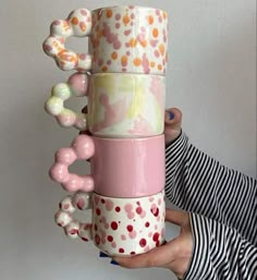 a stack of coffee mugs that are stacked on top of each other in different designs