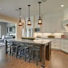 a large kitchen with an island in the middle and lots of stools around it