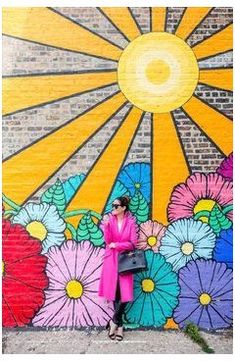 a woman standing in front of a colorful wall