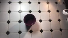 two coffee cups sitting on top of a white tiled floor next to a cup holder