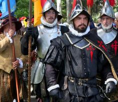 several men dressed in medieval costumes and holding flags