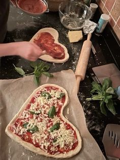 someone is making a heart shaped pizza in the kitchen