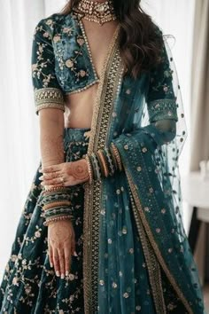 a woman wearing a blue lehenga and jewelry