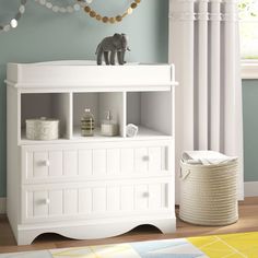 a baby's room with blue walls and white furniture