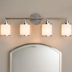 a bathroom vanity light with three lights and a mirror in front of the sink area