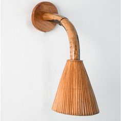 a wooden light fixture mounted on the side of a white wall next to a lamp shade