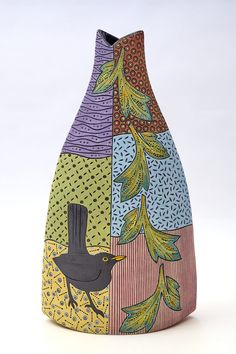 a colorful vase with an image of a bird on it's front and sides