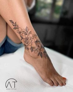 a woman's foot with a flower tattoo on her left side and the bottom part of her leg