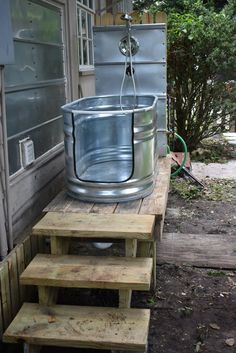 a metal tub sitting on top of wooden steps