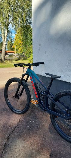 a blue and red bike parked next to a building