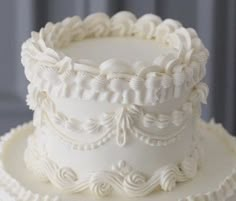 a three tiered white wedding cake with intricate decorations on the top and bottom layer